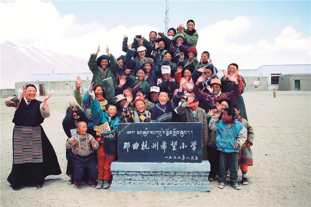 那曲杭州希望小学建成时，老师和学生在石碑前合影留念�?�那曲市色尼区委宣传部提�?.jpg