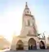 L'image capture l'apparence majestueuse de la cathédrale de Berne, enveloppée par la lumière éclatante du soleil matinal qui illumine la rue historique.