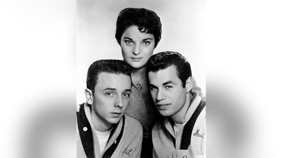 Carol Connors standing above her band members of the Teddy Bears