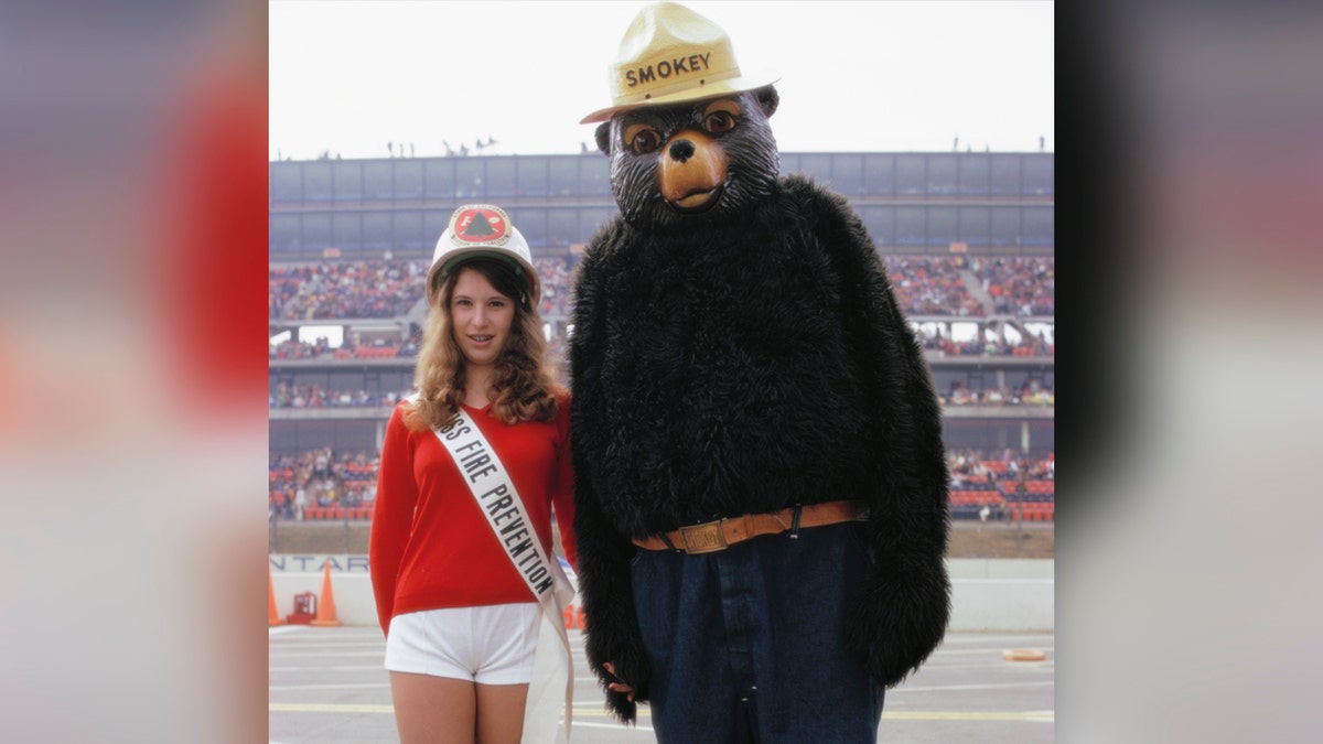 Young Miss Fire Prevention and Smokey the Bear appear at the Indianapolis International Speedway.