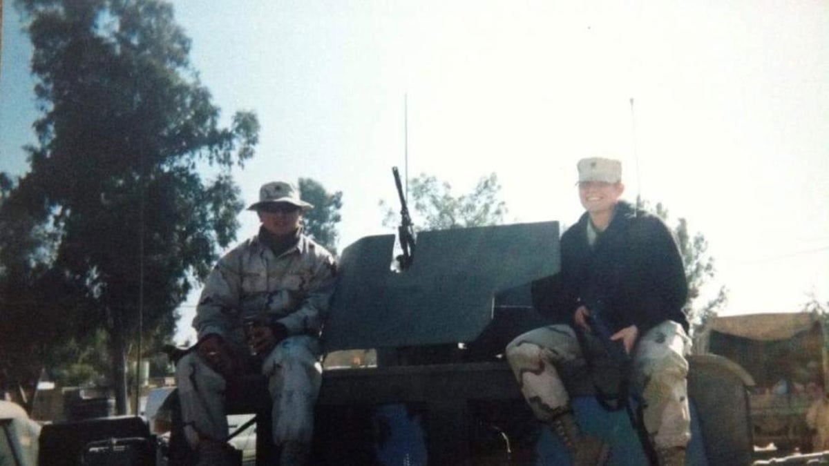 Jennifer Horn in military gear smiling next to a man who is also in uniform.