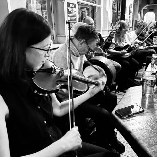 Fiddle, bodhrán, box, banjo, and more fiddles all in a row.