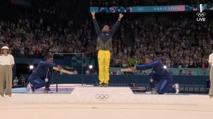 Simone Biles and Jordan Chiles bow to Rebeca Andrade on the podium after the women's floor final