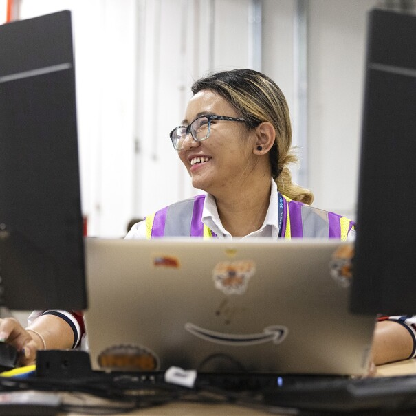 A photo of an Amazon employee taking an online course on desktop and laptop devices.