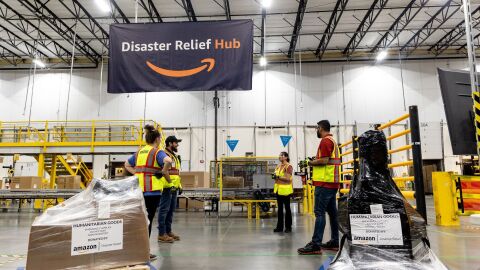 Amazon-donated humanitarian goods stacked on warehouse shelves