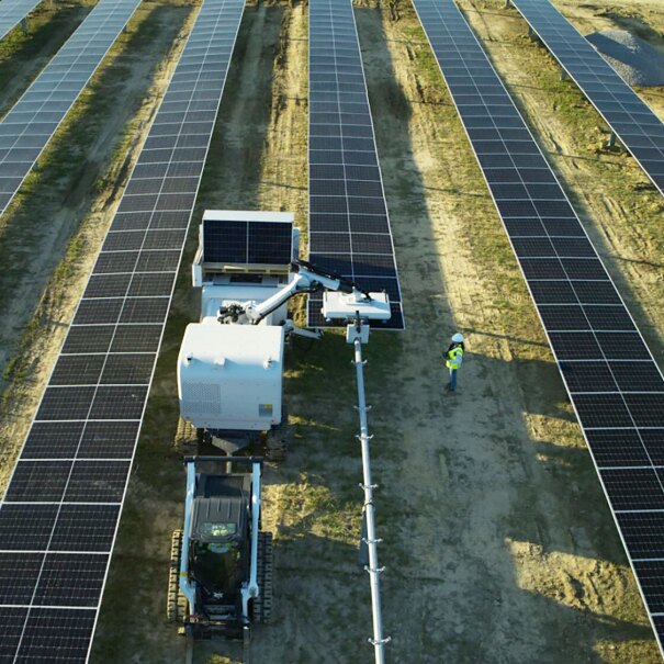 Overhead shot of workers at a solar power station working with AI-powered robot