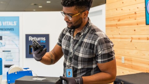 Amazon employee  processing returns at customer service counter