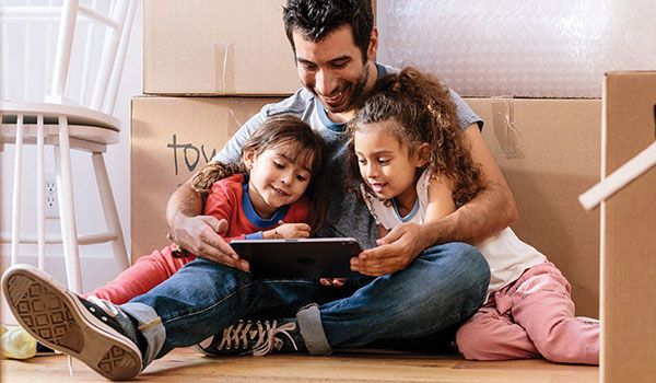 dad-hugging-daughters-and-looking-at-tablet