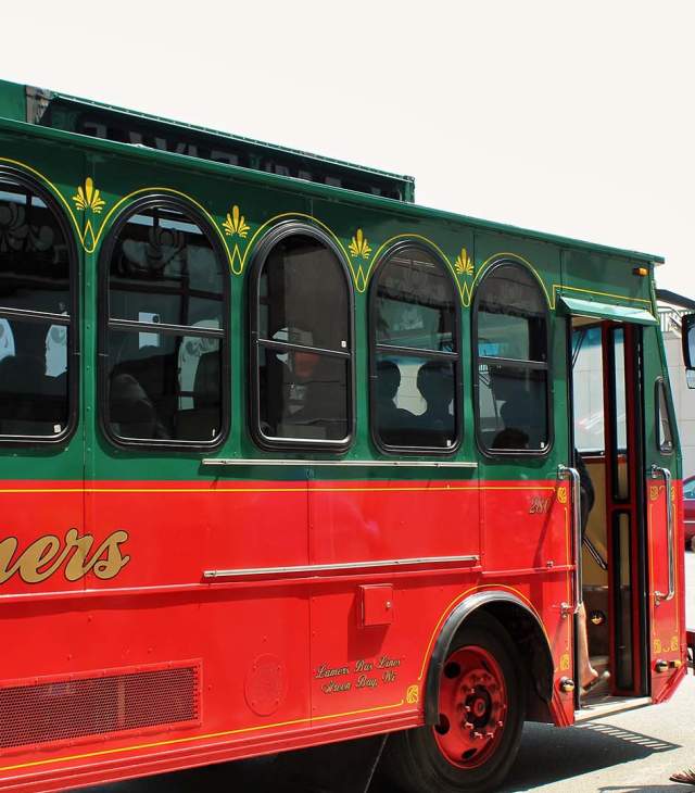 Man getting on a tour bus in front of Lambeau Field