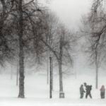 People stand in Boston Common amid a snowstorm