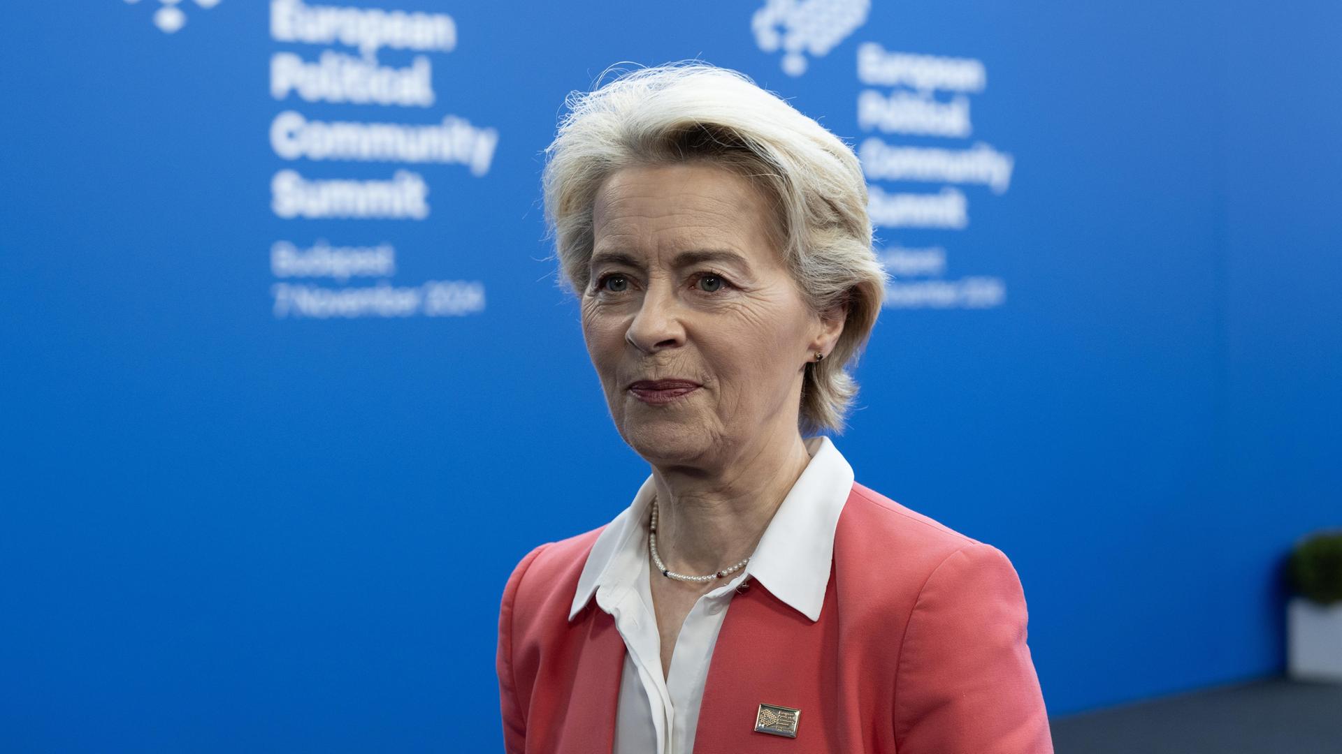 Portrait von der EU-Kommissionspräsidentin Ursula Leyen, sie trägt ein pfirsischfarbenes Sakko und läuft an dem Fotografen vorbei