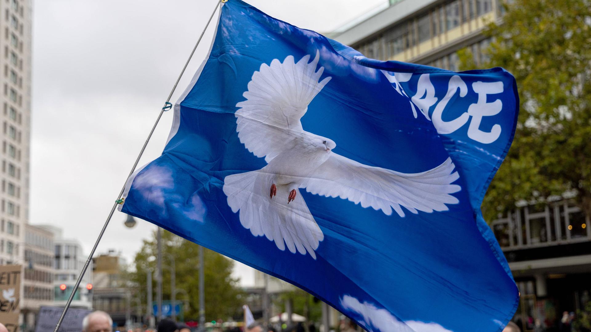 Fahne mit Friedenstaube bei der Demonstration "Die Waffen nieder" am Breitscheidplatz in Berlin