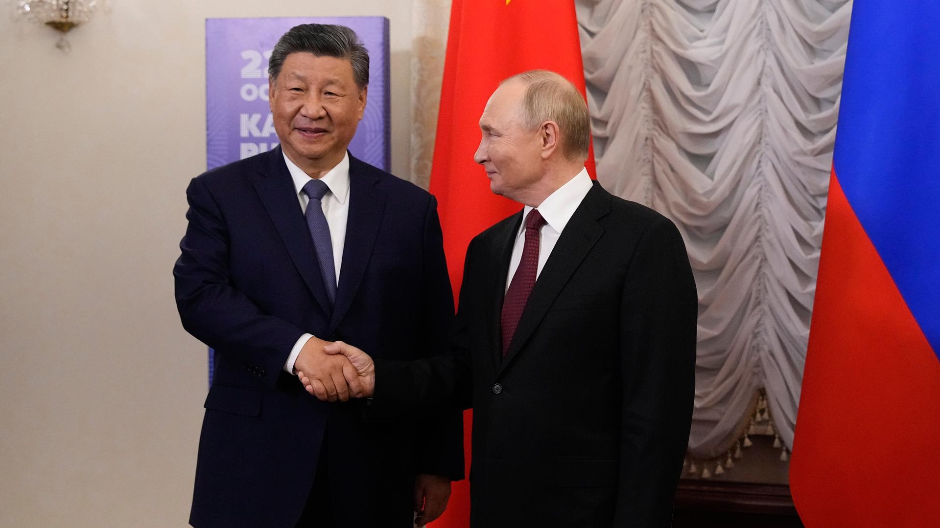 Russlands Präsident Putin und Chinas Präsident Xi Jinping schütteln sich beim BRICS-Gipfel die Hand.