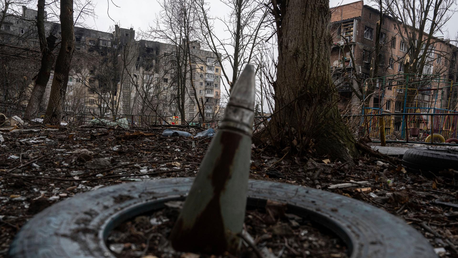 Ukraine, Wuhledar: Ein Teil einer Rakete ragt aus dem Boden vor einem Wohnhaus, das von den russischen Streitkräften schwer bombardiert wurde. 