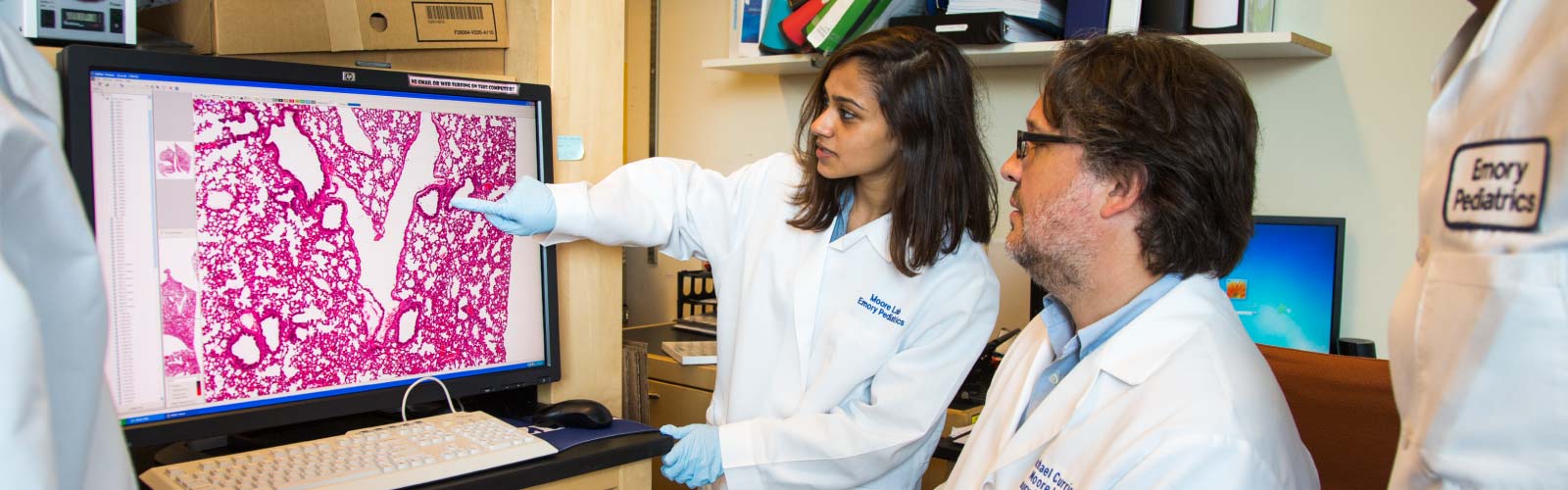 Two people looking at a computer screen in a lab