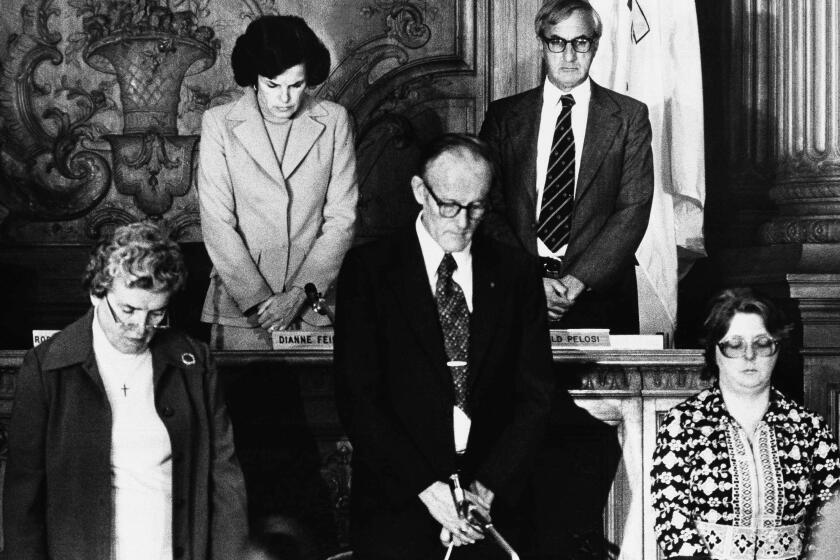 The San Francisco Board of Supervisors, presided over by president and now acting Mayor Dianne Feinstein, top left, bow their heads in silence for Mayor George Moscone and Supervisor Harvey Milk who were shot to death at City Hall in San Francisco, Nov. 27, 1978. Others are unidentified. (AP Photo/A. Cope)