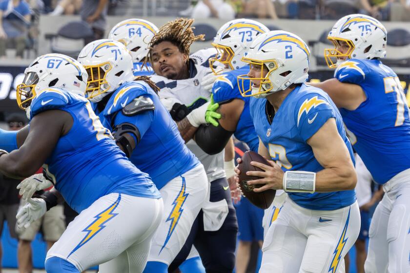 Chargers quarterback Easton Stick gets chased out of the pocket by the Seattle Seahawks during a preseason game 