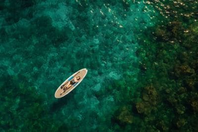 Woman floating on a paddleboard in the ocean.