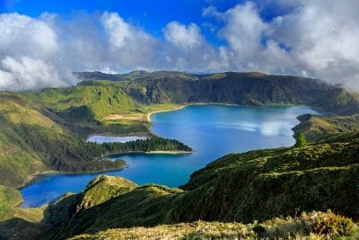 A blue lake is surrounded by green hills