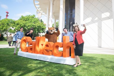 Laurie Leshin taking a selfie with Caltech's mascot and community members.