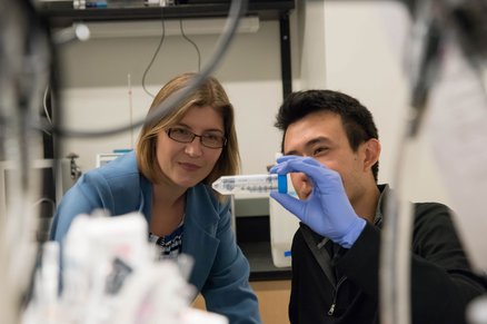 Viviana Gradinaru looking at a graduated tube with a research student.