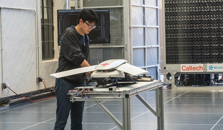 An individual works on a drone in the lab.