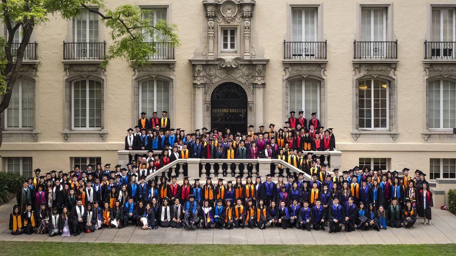 Caltech's undergraduate class of 2023 stand together in graduation regalia on campus.