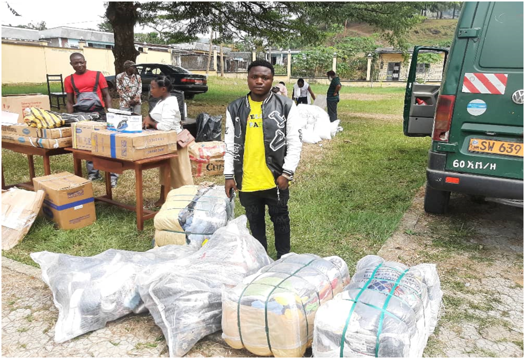 Mbah Marcel jeune bénéficiaire IDP recevant des ballots de vêtements et chaussures pour shopping