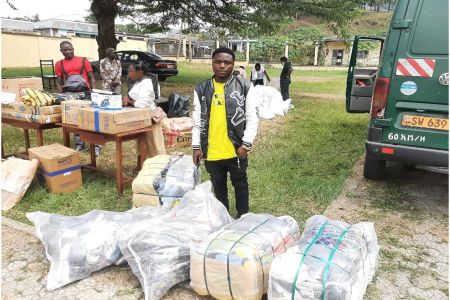 Mbah Marcel jeune bénéficiaire IDP recevant des ballots de vêtements et chaussures pour shopping