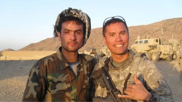Two people in camouflage smiling
