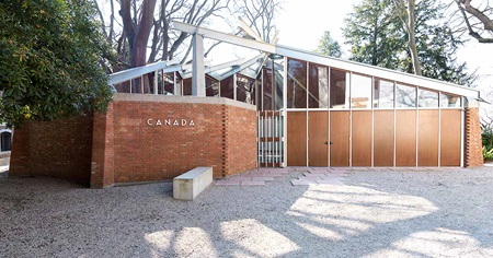 A glass and brick exhibition building with Canada printed on the side.