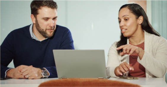 photo of two employees collaborating with a laptop