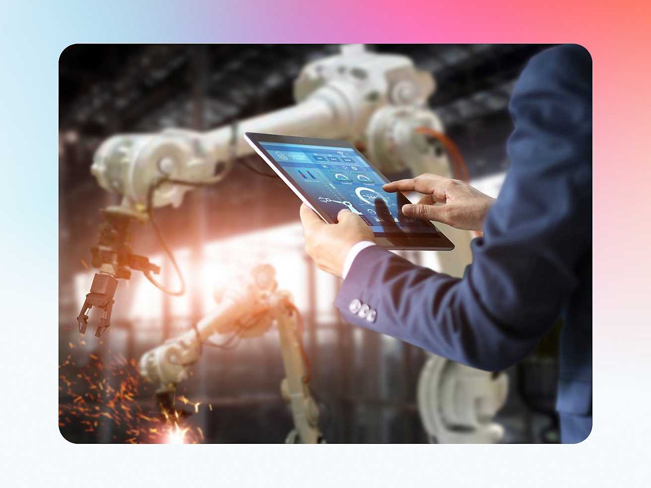 A person in a factory controls robotic arms using a tablet, highlighting advanced automation technology.