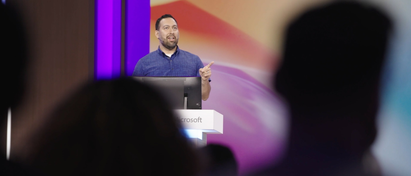 A speaker standing on a podium with Microsoft written on it