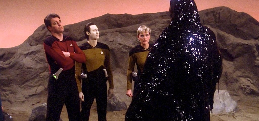 Three members of the Star Trek Enterprise away team confront the Skin Of Evil