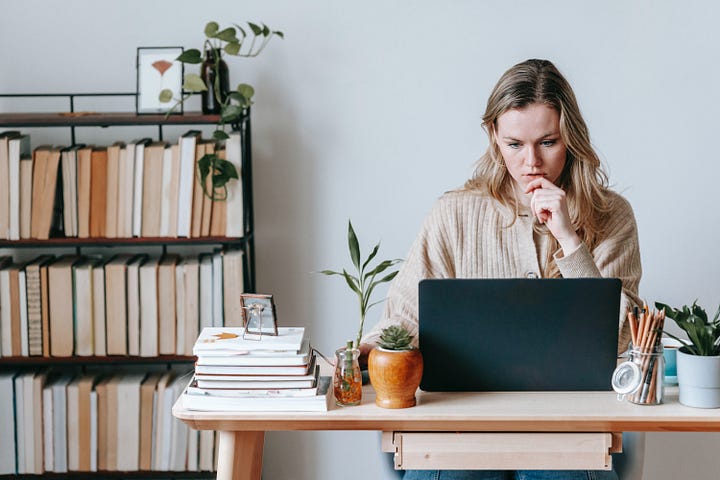 Woman staring intently at a laptop.