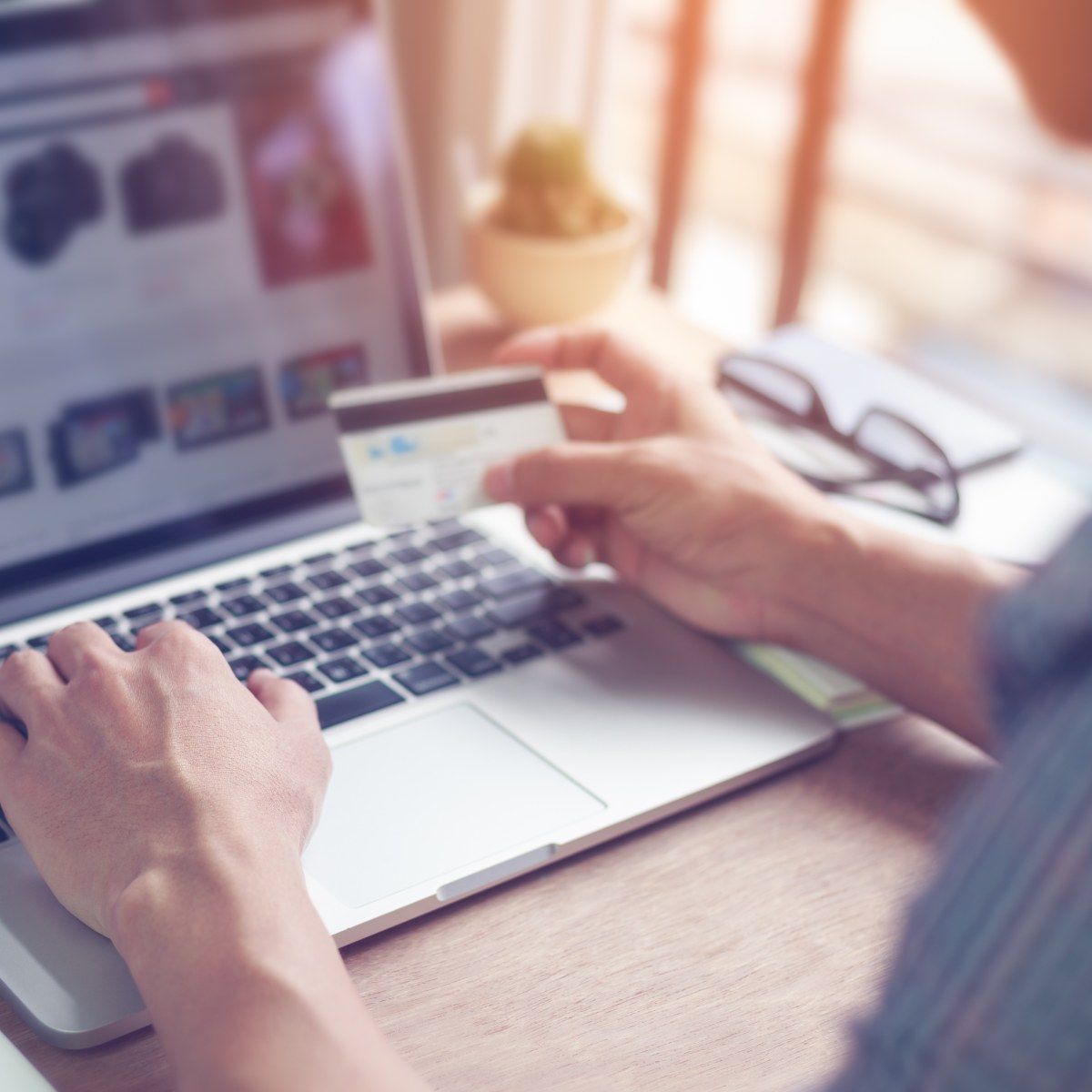 A man types his credit card information into an online shopping site