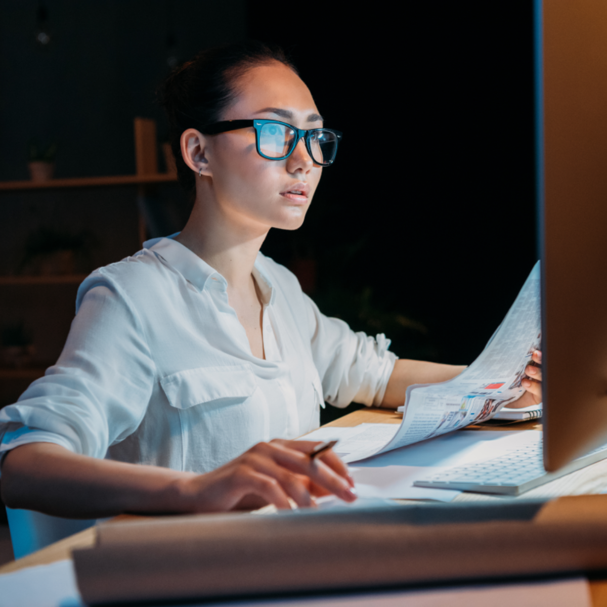 A woman uses her computer at night.