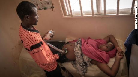 The camp nurse, Isa Umar examines a pregnant woman during antenatal session