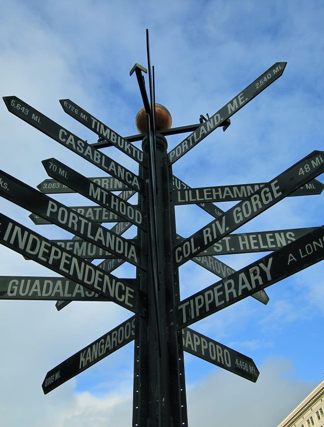 a city street sign with many street signs pointing in separate directions