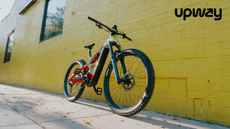 picture of a red bike resting on yellow wall