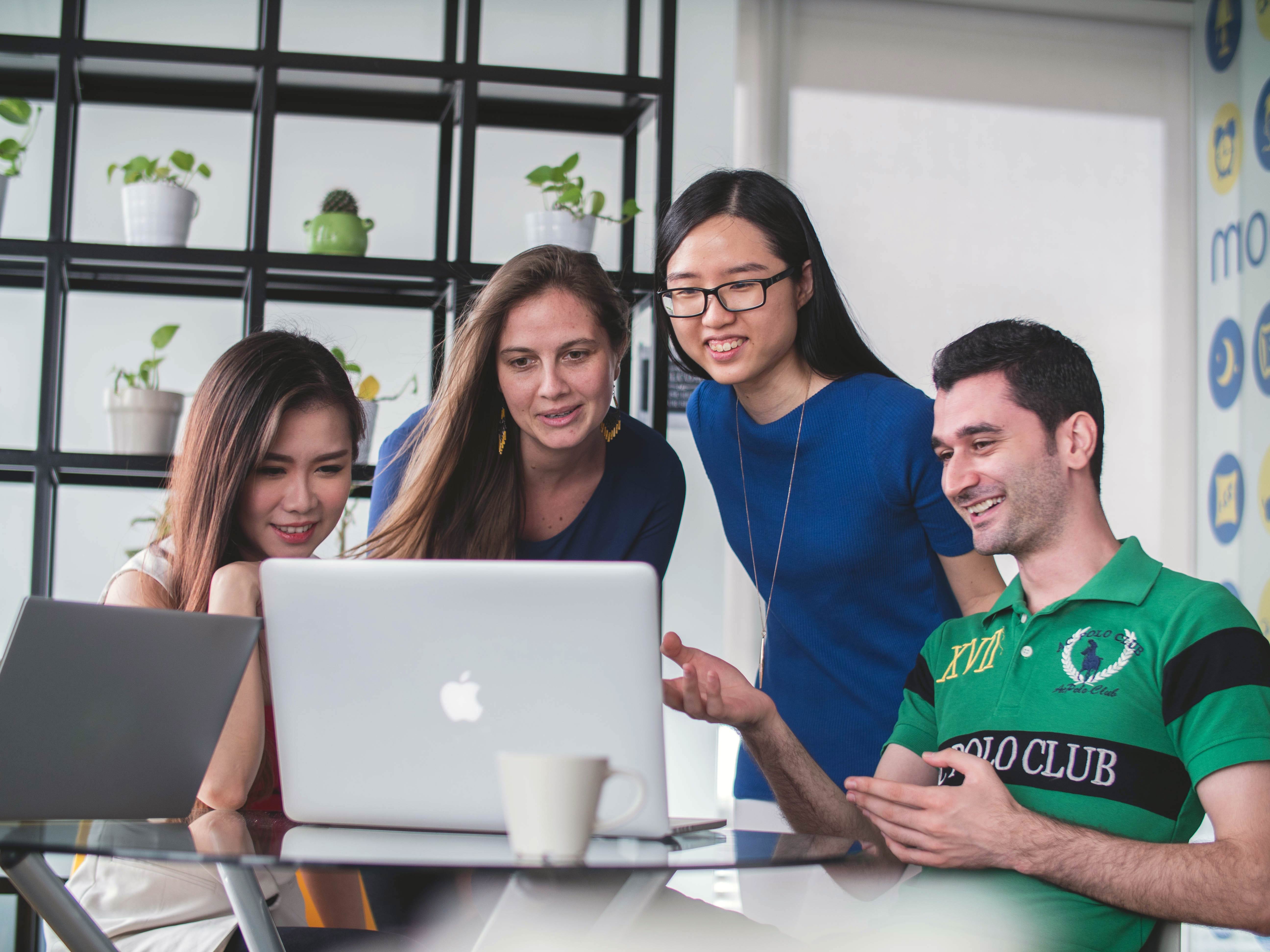 three women and one man student looking at Mac