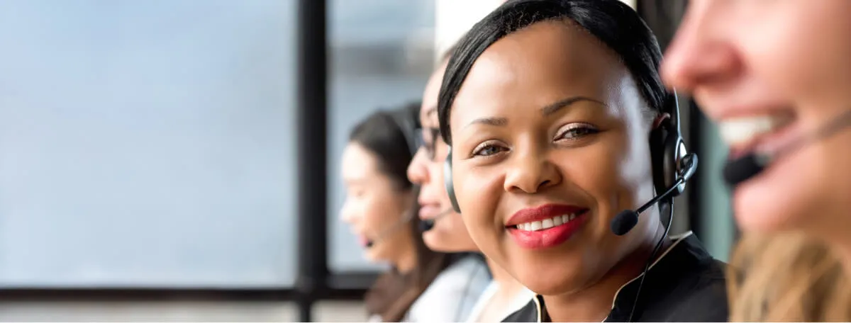 A smiling woman wearing a headset and looking at the camera