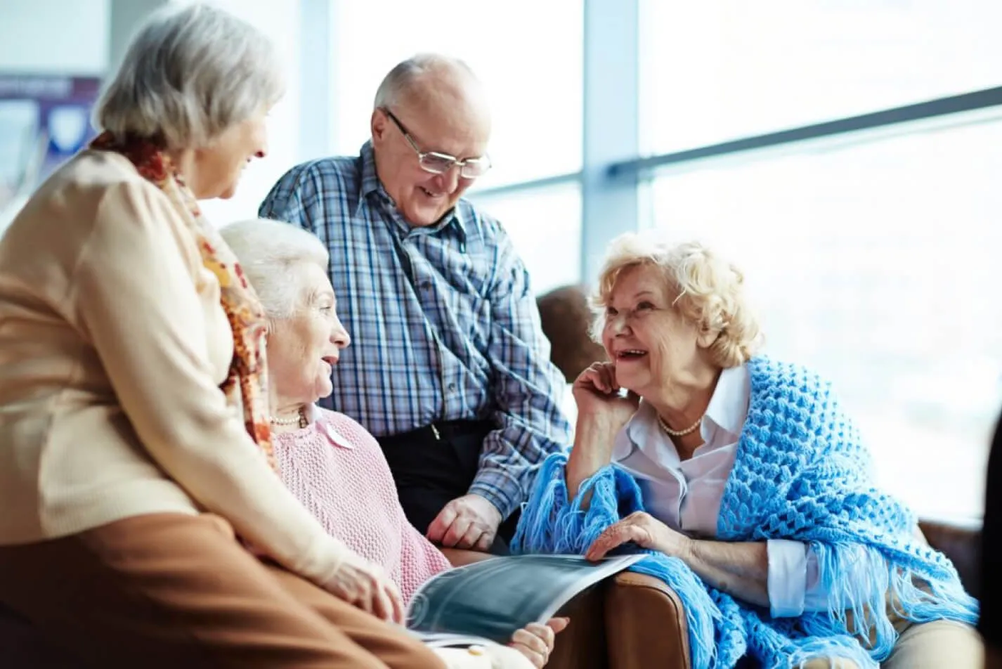 A group of older people chat and laugh