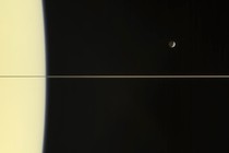 A photograph of Saturn's moon, Mimas, above Saturn's ring