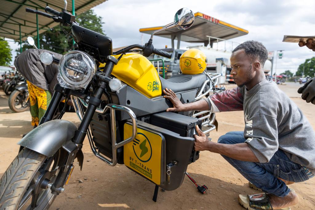 A rider examines his electric motorbike taxi. The taxi is part of a pilot GEF e-moto program in the Lome region of Togo