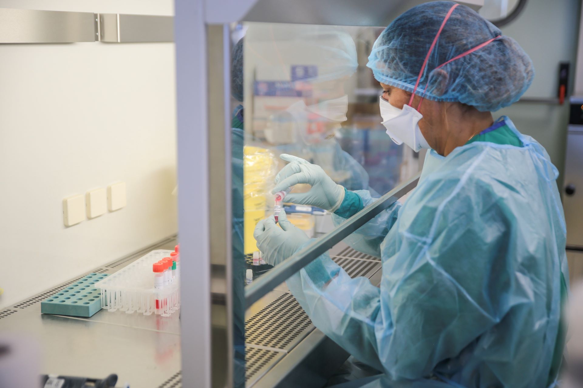 Lab technician mixes samples in a biosafety cabinet