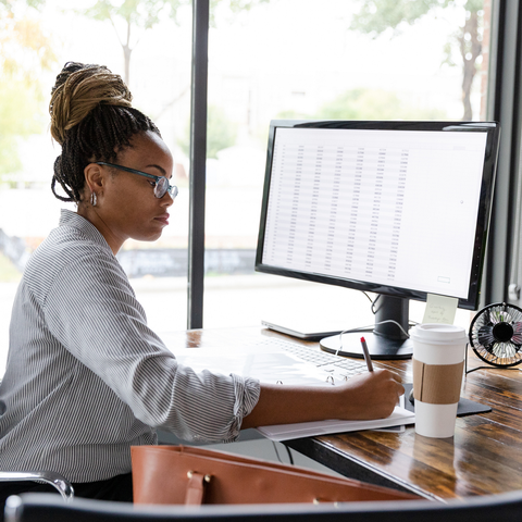 person writing at desk