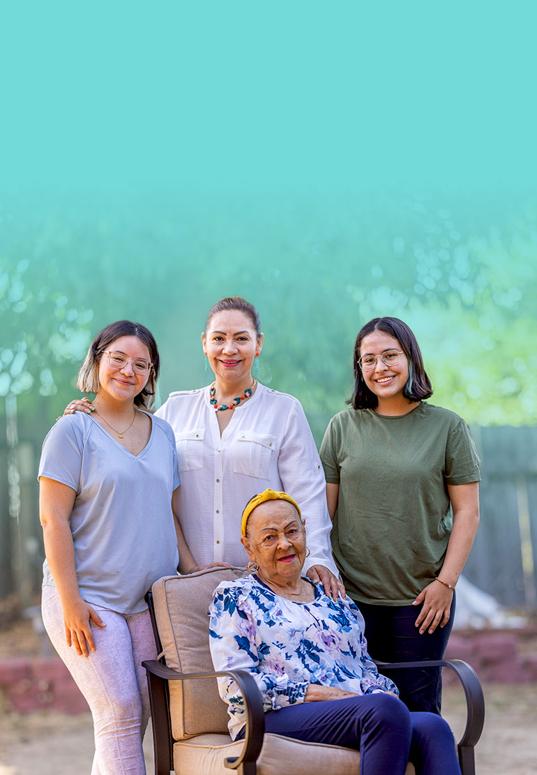 Four women, of three generations, pose for a family portrait.