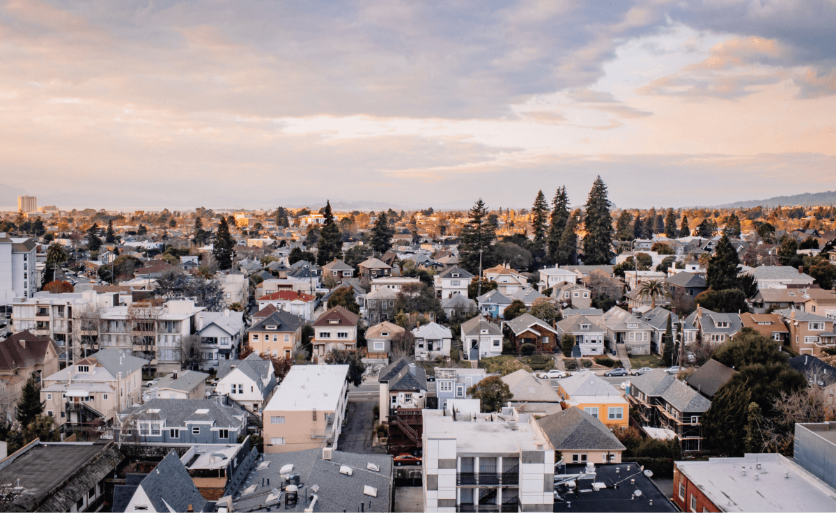 Aerial view of a cityscape with houses and trees, showcasing the urban landscape and natural surroundings.